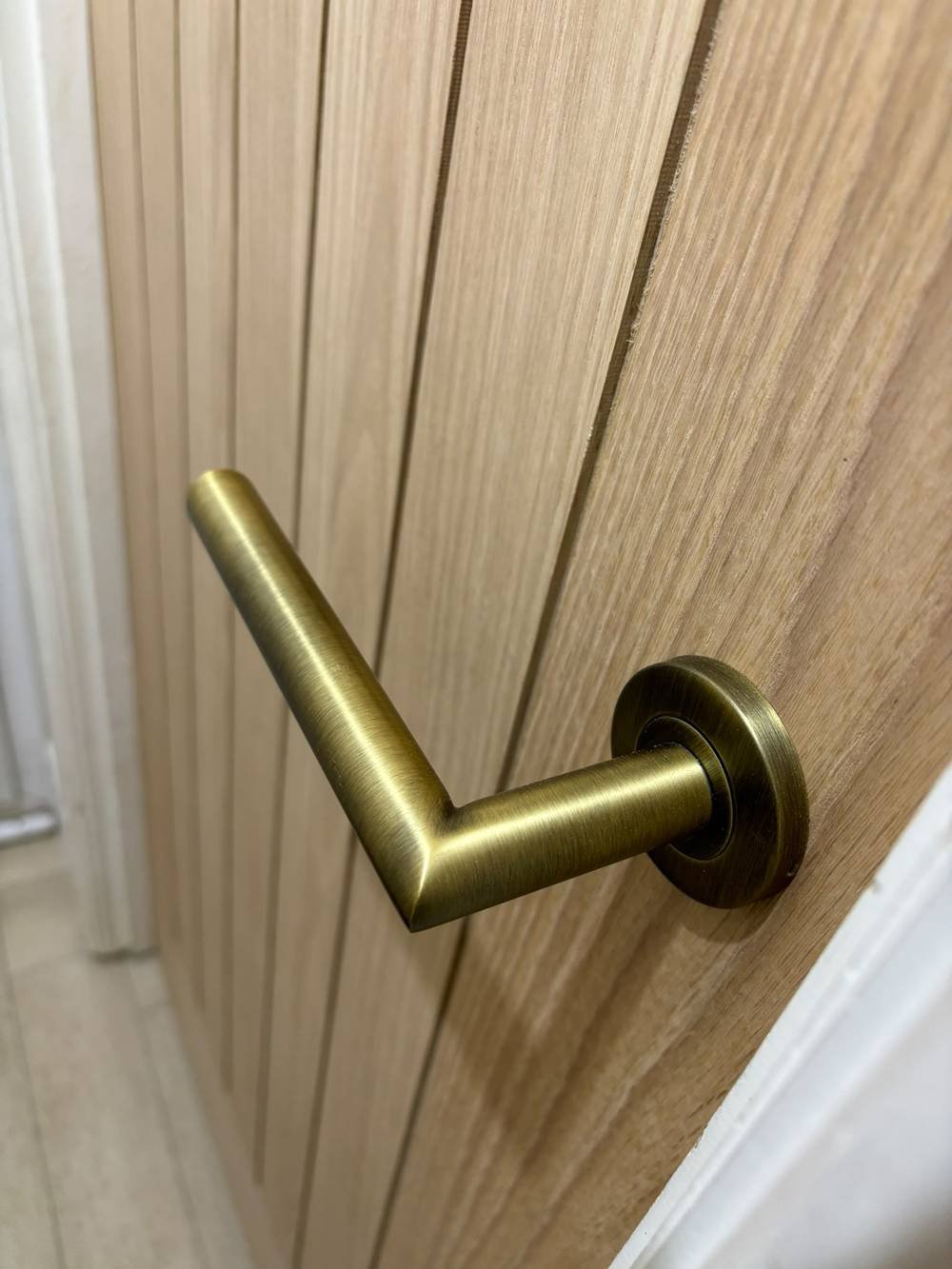 Brass lever door handle on an oak panelled door