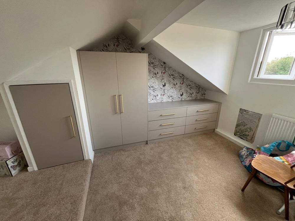 Fitted wardrobe and drawers built into a sloped eaves space