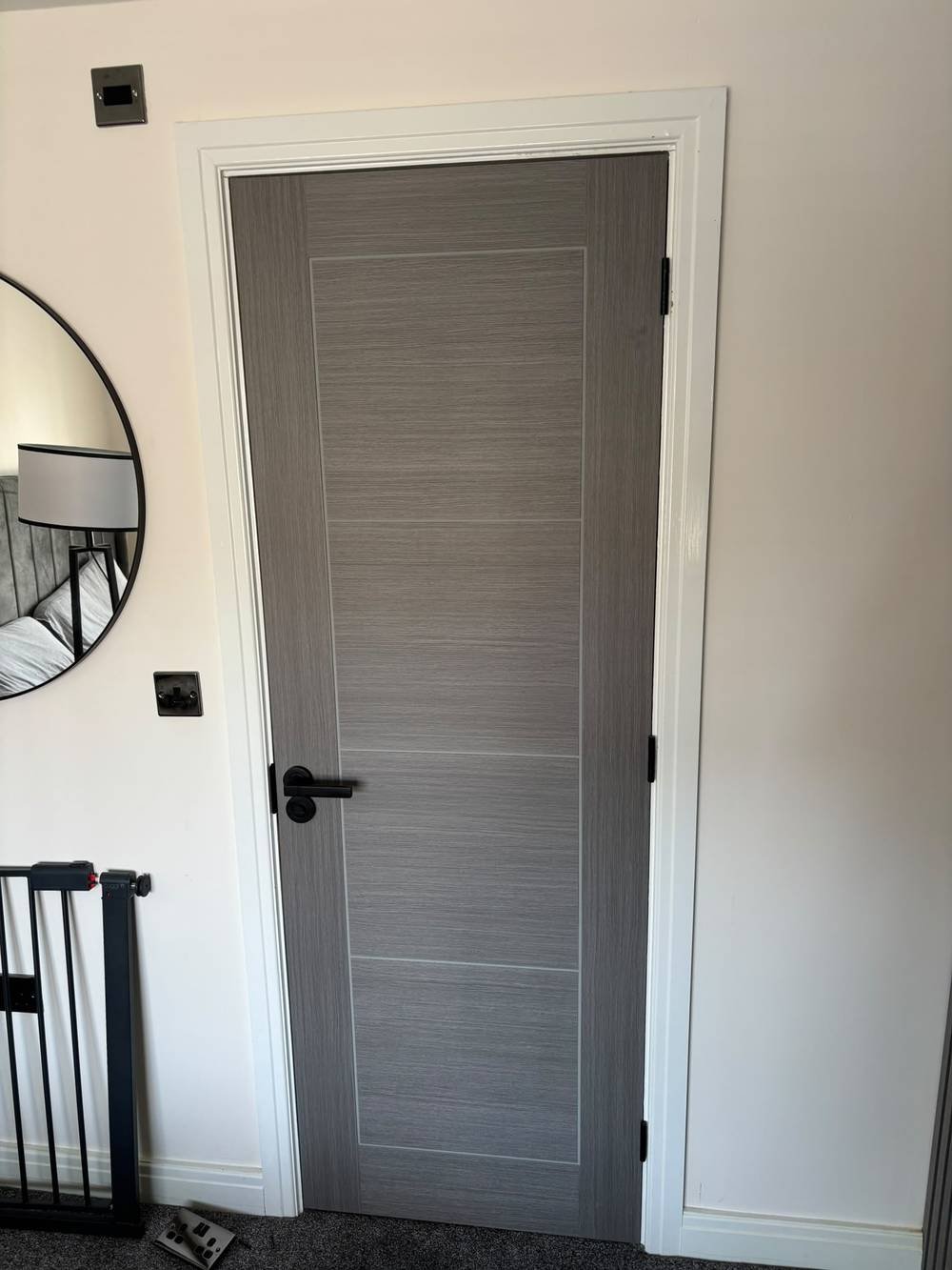 Grey woodgrain internal door with black handle