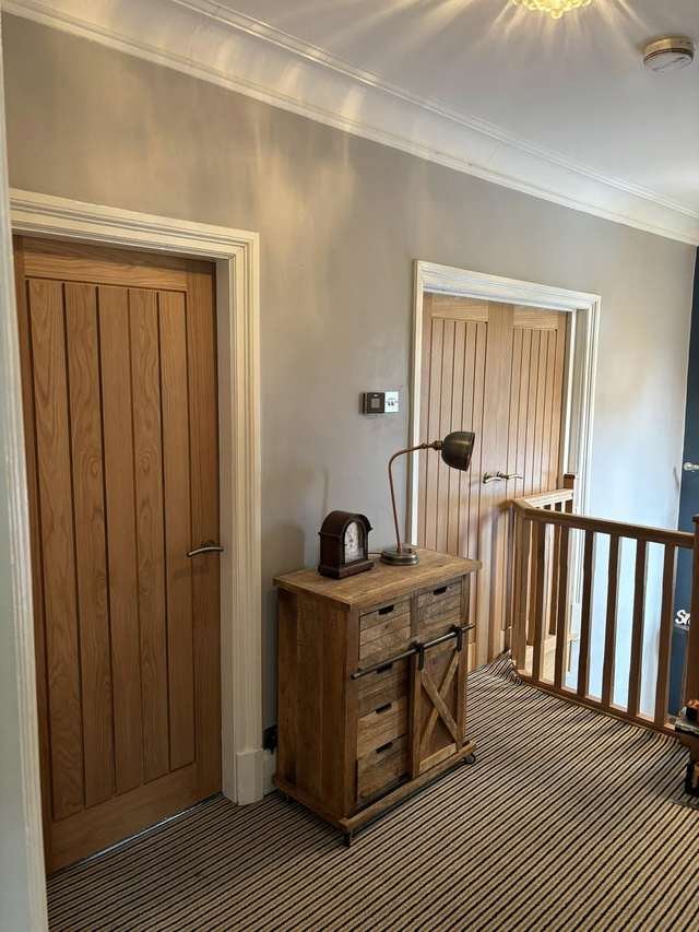 Hallway with fitted oak doors and landing detail