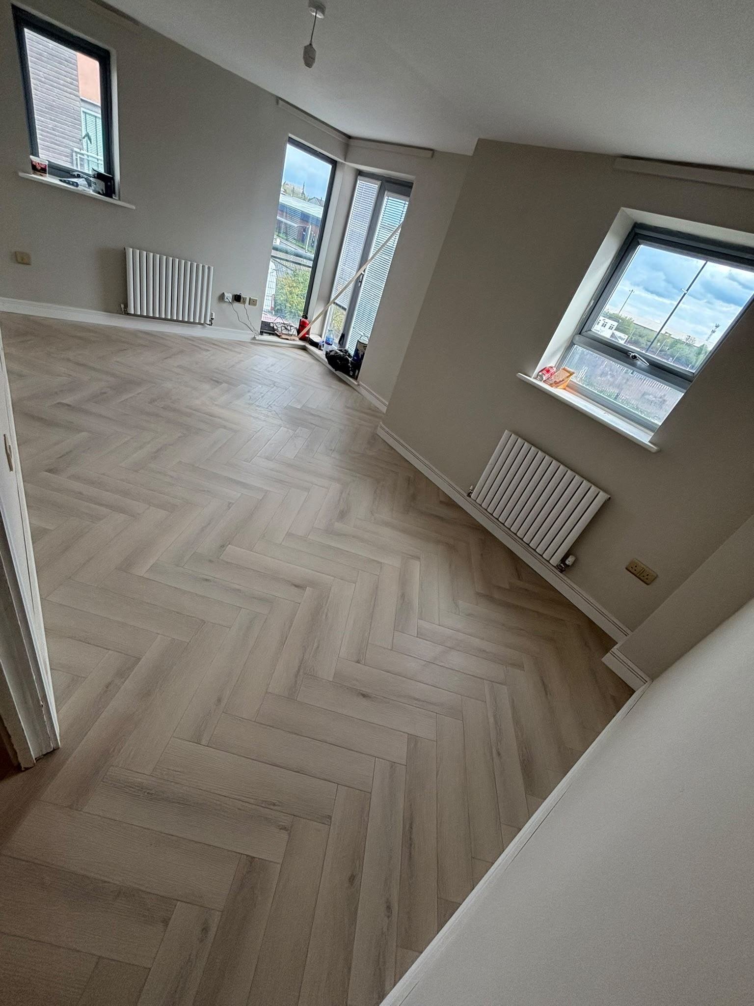 Herringbone flooring fitted in an open-plan living space with bay window, Manchester