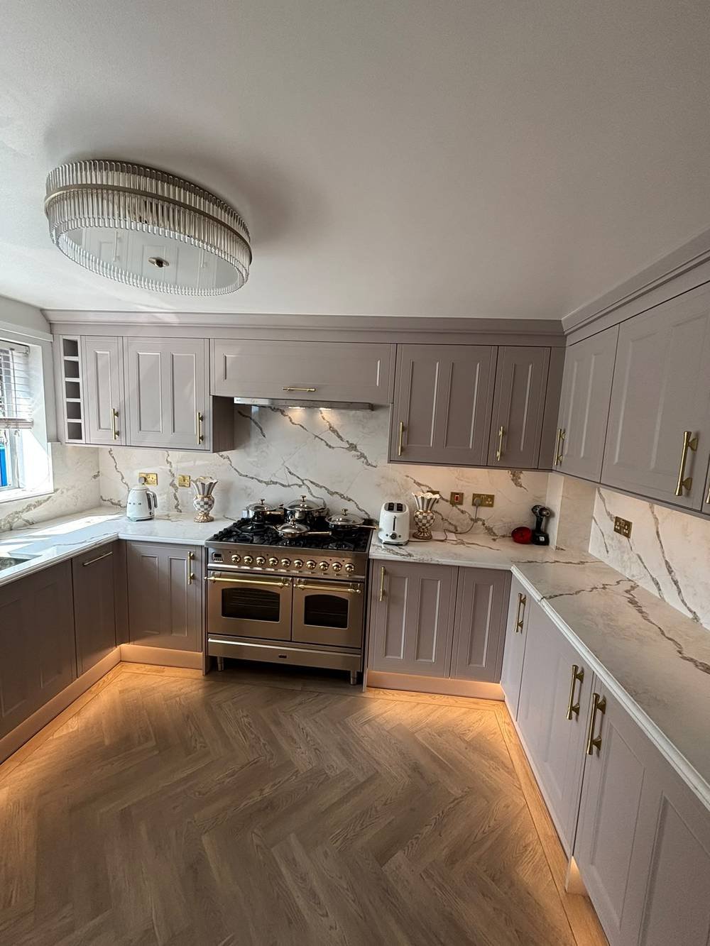 Kitchen fitted around a range cooker with herringbone flooring