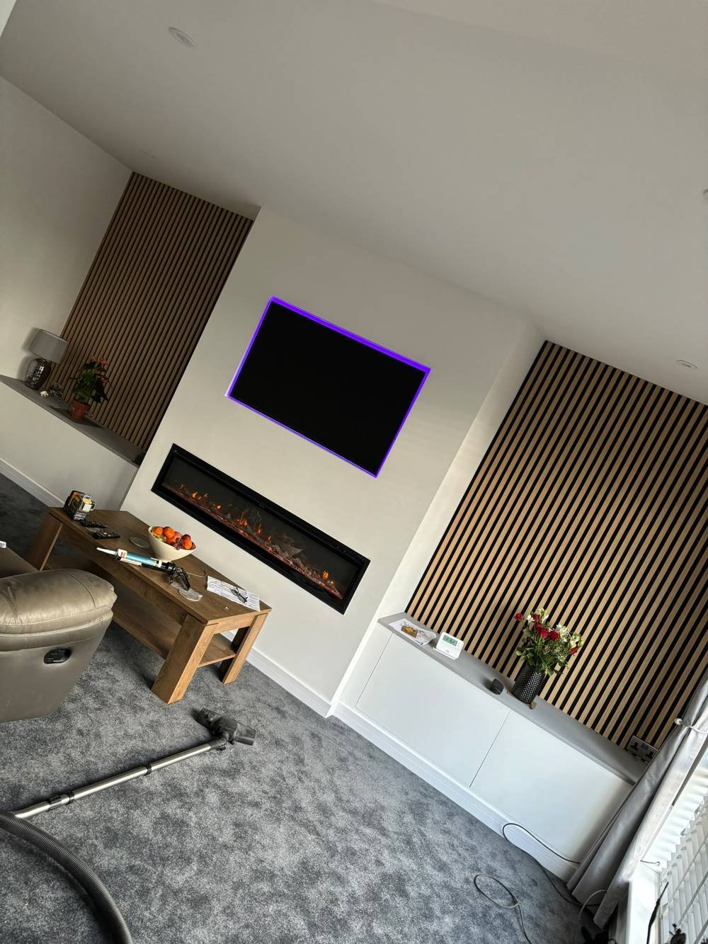 Media wall with LED-backlit TV recess and fitted cabinetry